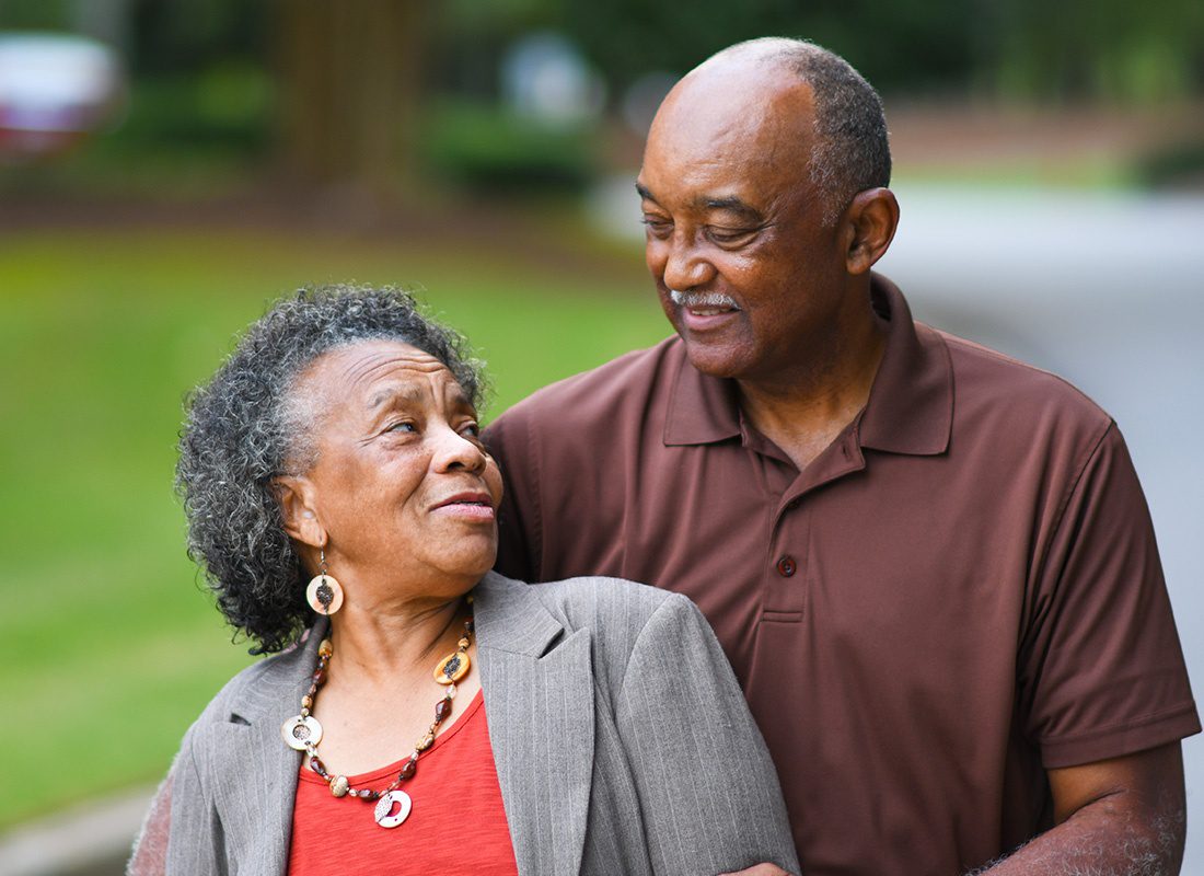 Medicare - Elderly Couple Look at Each Other Lovingly While on a Walk